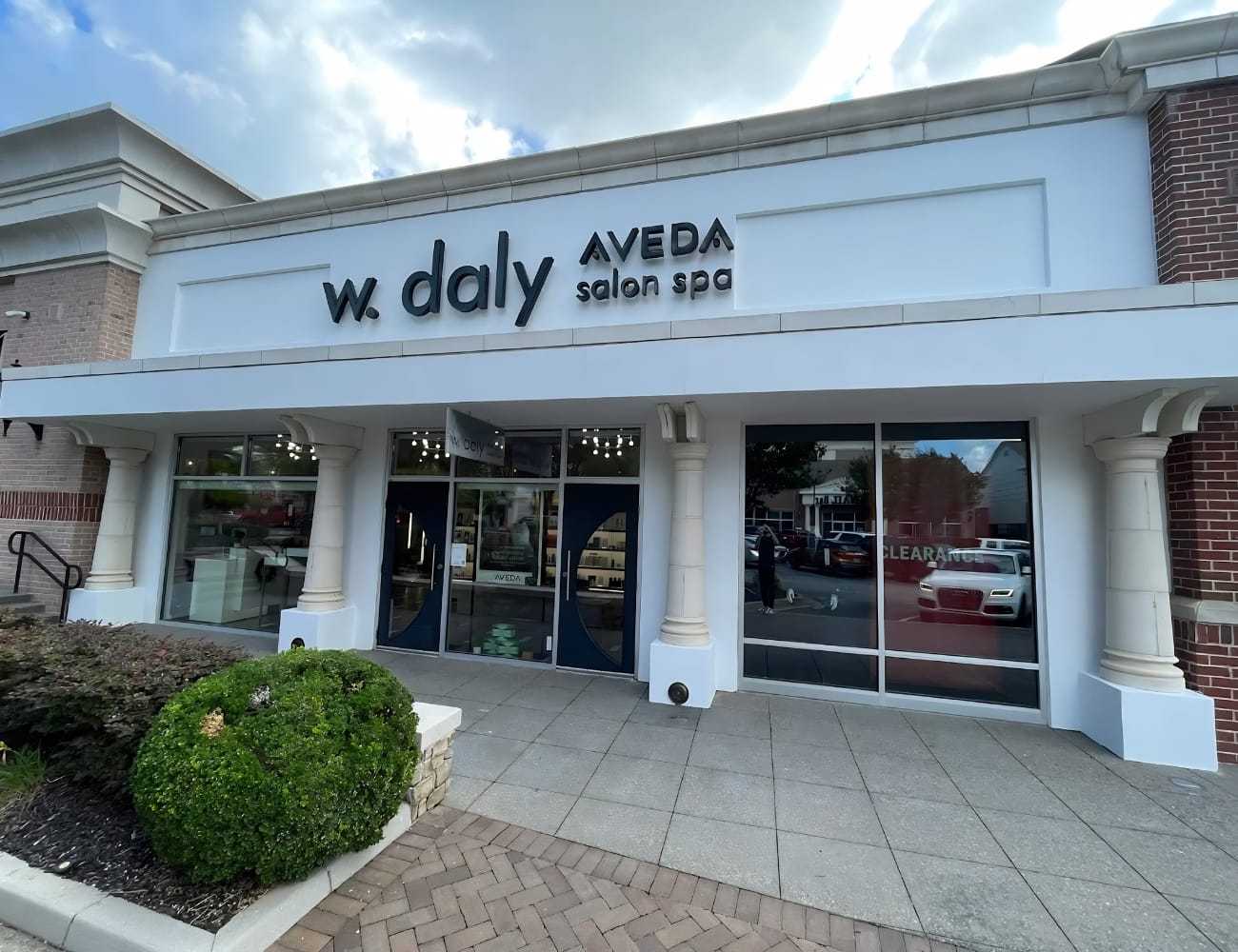 Exterior of W. Daly Aveda Salon Spa with large signage and glass entrance.