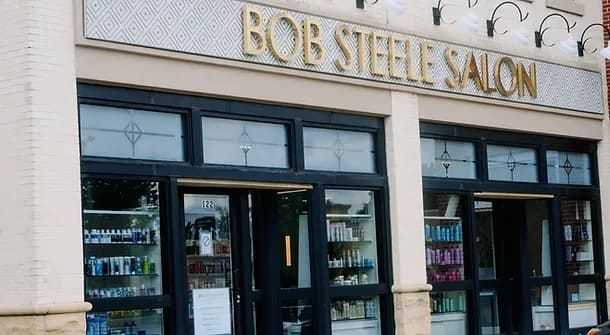Front view of Bob Steele Salon with large windows showcasing hair products on display shelves.